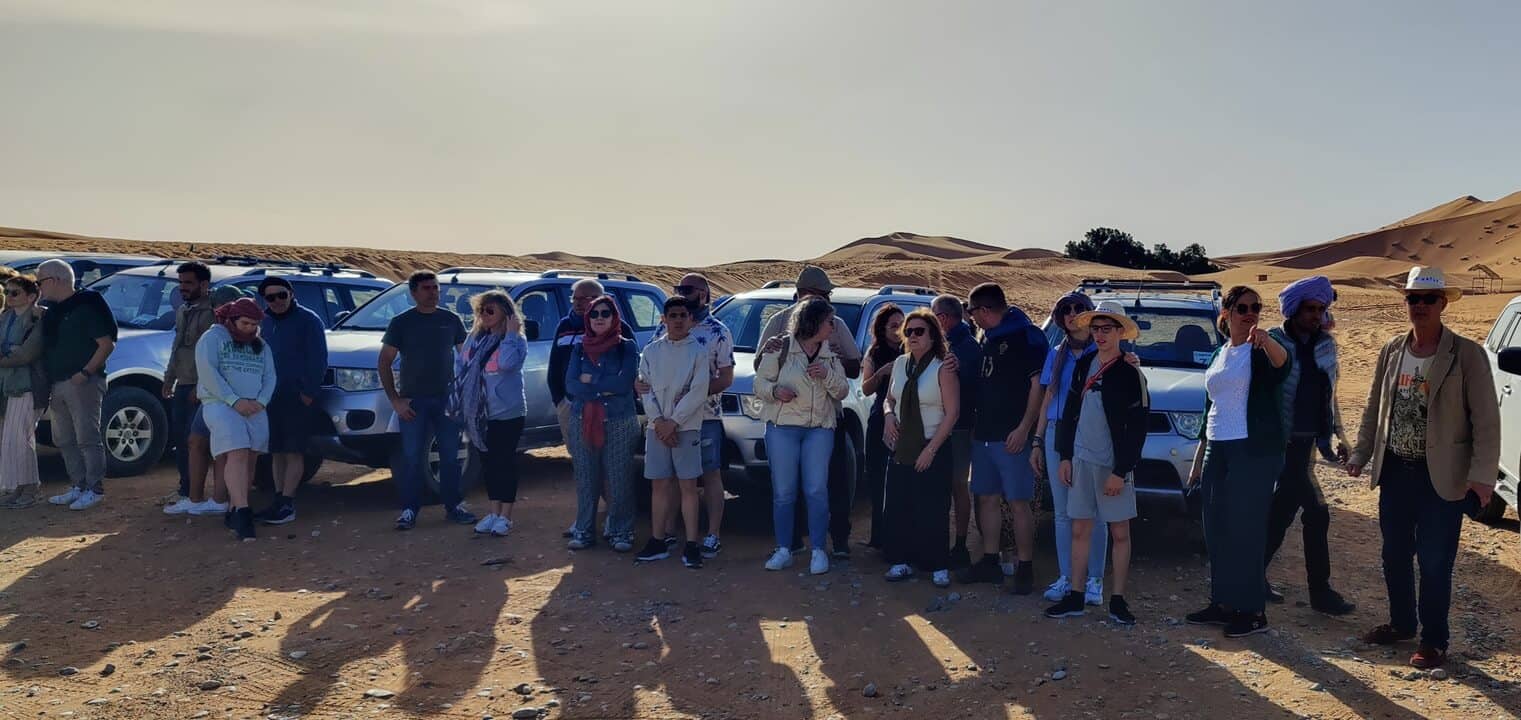 Travelers enjoying a Morocco Sahara Desert tour near the Merzouga dunes