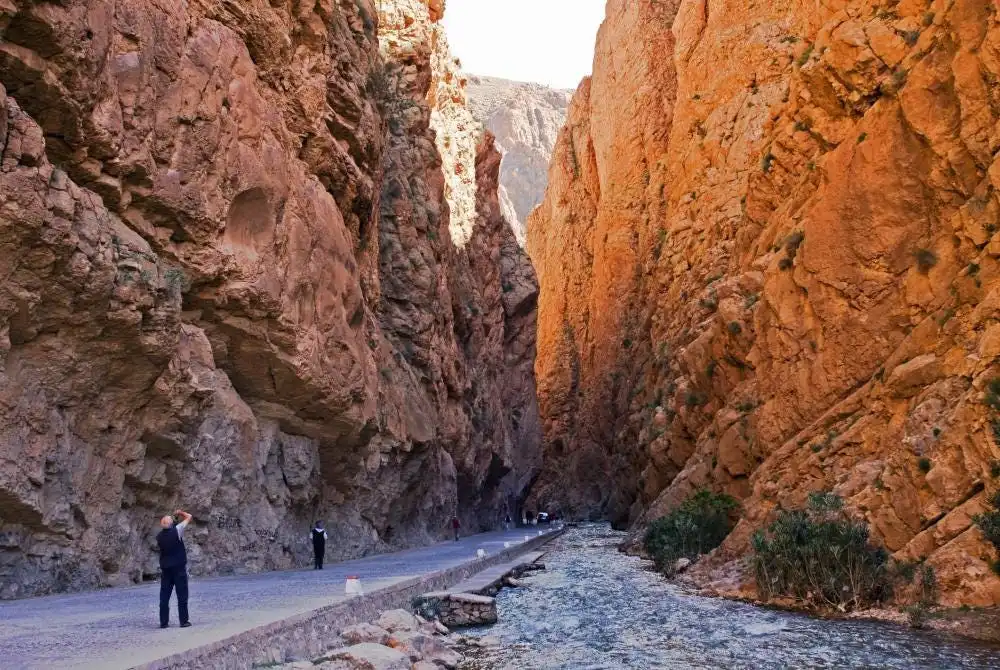 Visitors strolling through the breathtaking Todra Gorge in Morocco, a must-see for anyone traveling to the region.