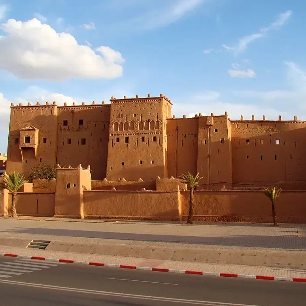Una gran e histórica kasbah con altos muros y torres fortificadas en Ouarzazate, Marruecos, bajo un cielo despejado. Palabras clave: Kasbah Taourirt, Ouarzazate, Marruecos, histórico, fortaleza.