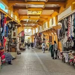 This image captures the vibrant scene of an old market in Rabat, likely showcasing traditional Moroccan goods, such as clothing, lamps, and crafts.