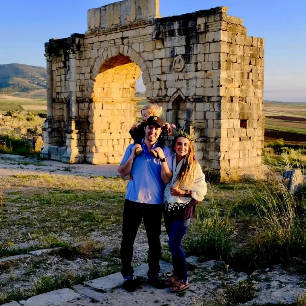 A tourist standing among the ancient columns and ruins of Volubilis, Morocco. Popular historical destination highlighting Roman architecture and attracting visitors from around the world.