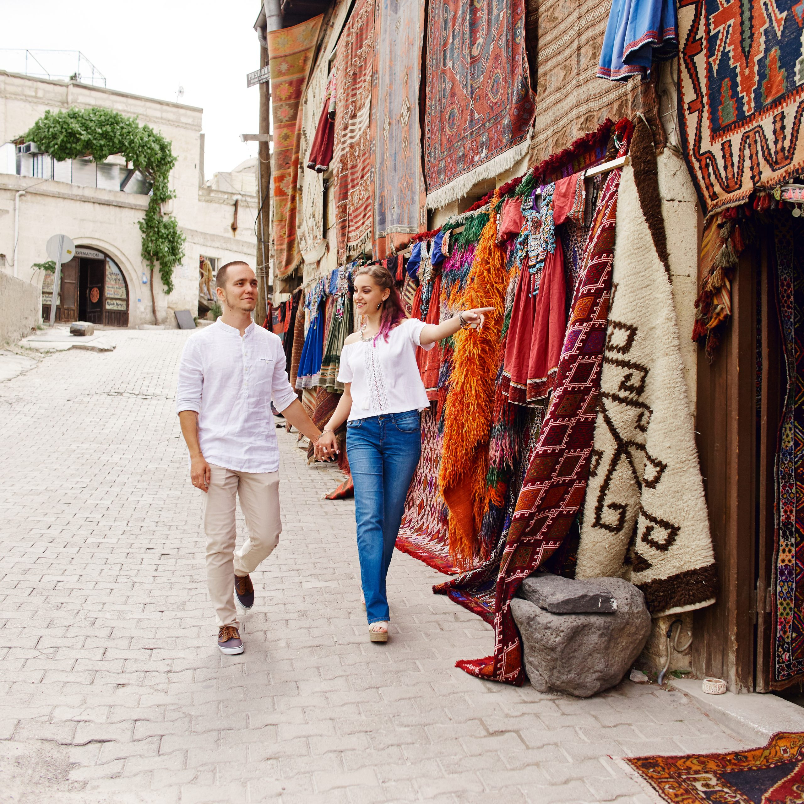Couple in love buys a carpet and handmade textiles at an oriental market inmorocco. Hugs and cheerful happy faces of men and women
