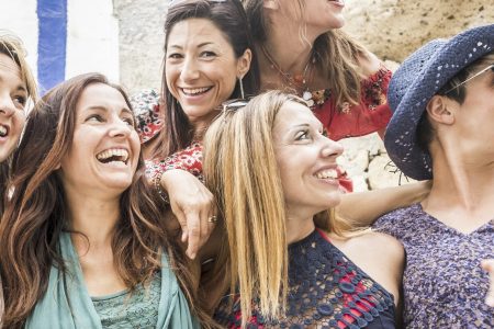 Group of cheerful happy young caucasian women hug and enjoy the