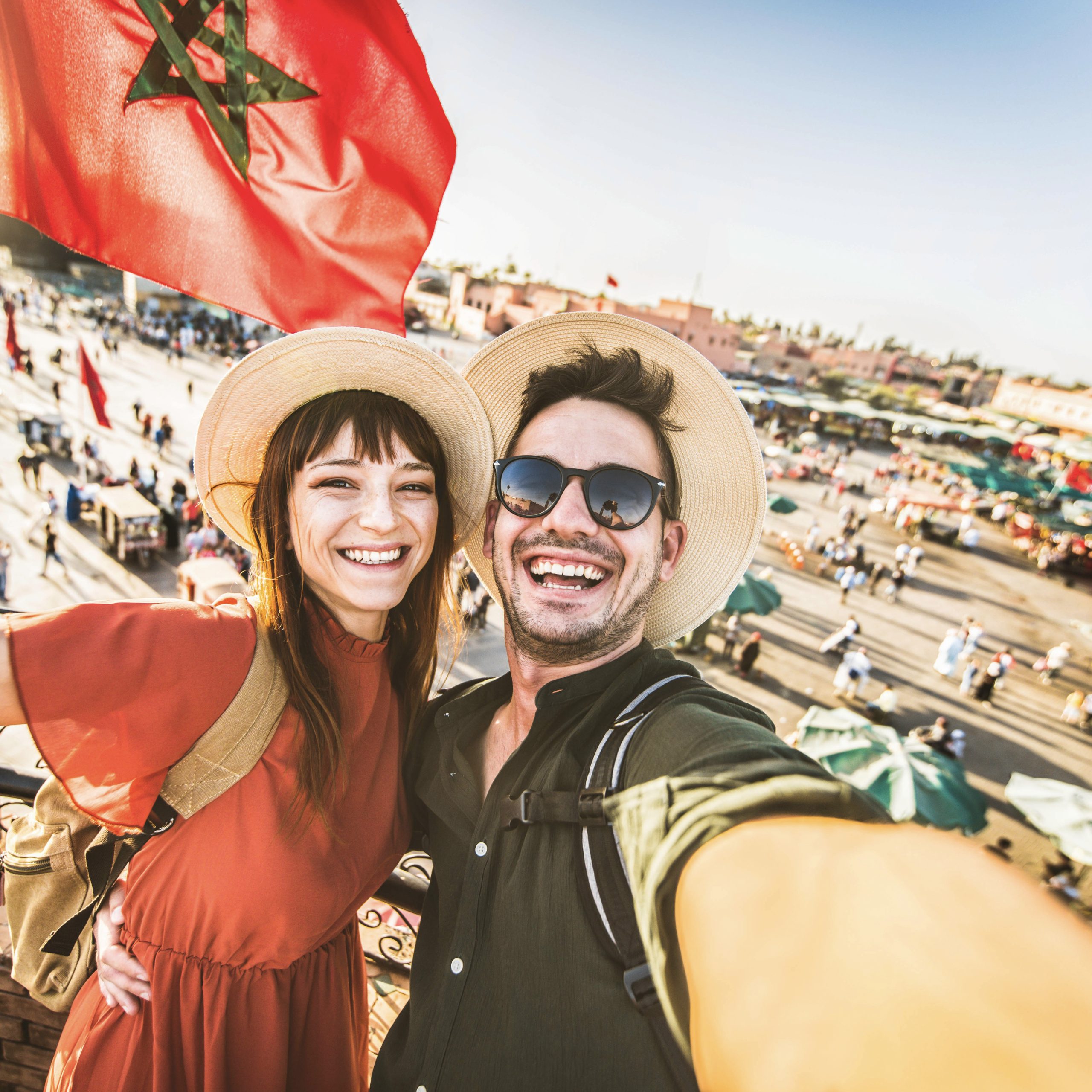 Happy tourists couple visiting Jamaa el-Fna market Marrakech, 12 days culture tour from casablanca​